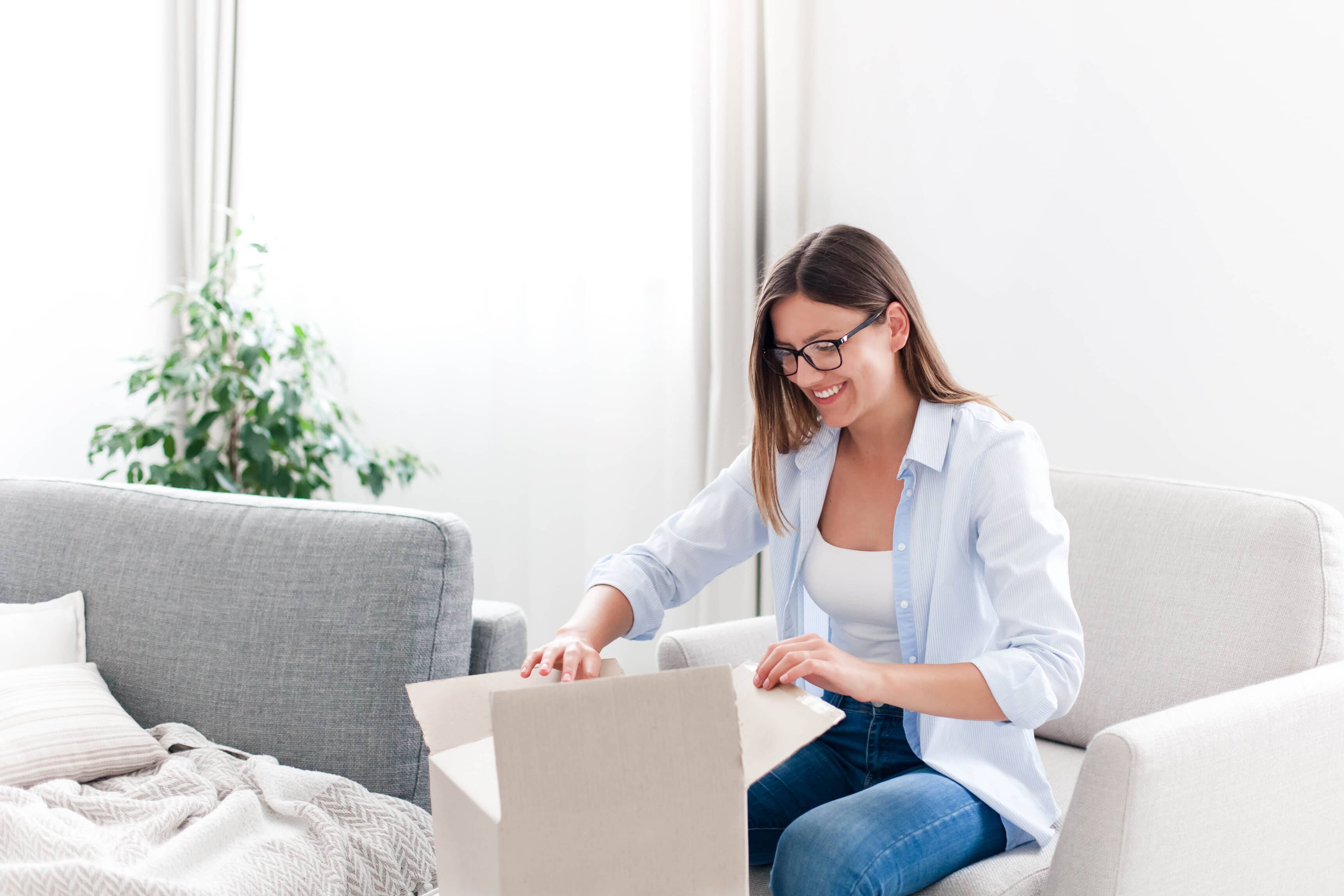 Young woman opening cardboard box